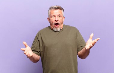 old senior man feeling extremely shocked and surprised, anxious and panicking, with a stressed and horrified look