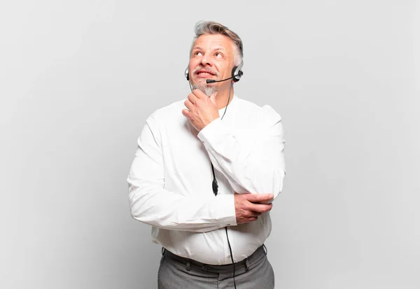 Teleoperador Sênior Sorrindo Feliz Sonhando Acordado Duvidando Olhando Para Lado — Fotografia de Stock