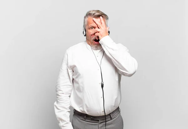 Senior Telemarketer Looking Shocked Scared Terrified Covering Face Hand Peeking — Stock Photo, Image