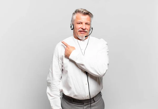 Teleoperador Sênior Sorrindo Alegremente Sentindo Feliz Apontando Para Lado Para — Fotografia de Stock