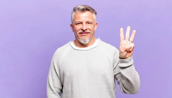 Alter Älterer Herr Lächelt Und Schaut Freundlich Zeigt Nummer Drei — Stockfoto