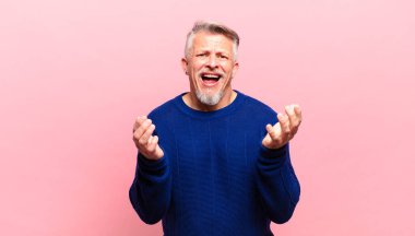 old senior man looking desperate and frustrated, stressed, unhappy and annoyed, shouting and screaming