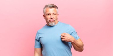 old senior man looking arrogant, successful, positive and proud, pointing to self