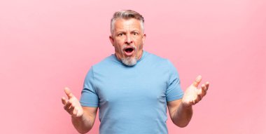 old senior man feeling extremely shocked and surprised, anxious and panicking, with a stressed and horrified look