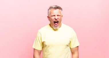 old senior man shouting aggressively, looking very angry, frustrated, outraged or annoyed, screaming no