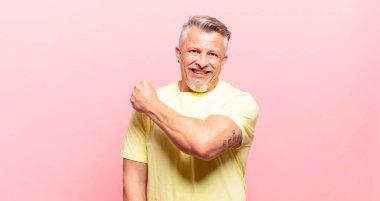 old senior man feeling happy, positive and successful, motivated when facing a challenge or celebrating good results