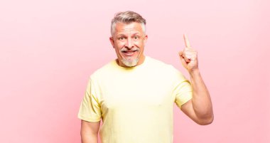 old senior man feeling like a happy and excited genius after realizing an idea, cheerfully raising finger, eureka!