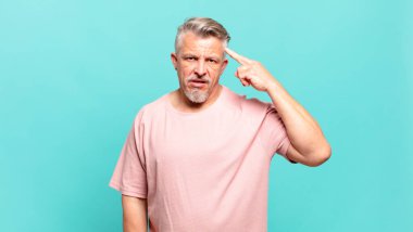 old senior man feeling confused and puzzled, showing you are insane, crazy or out of your mind