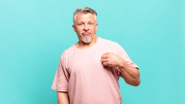 old senior man looking arrogant, successful, positive and proud, pointing to self