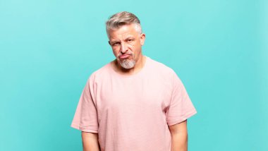 old senior man feeling puzzled and confused, with a dumb, stunned expression looking at something unexpected