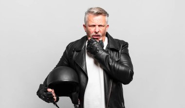 Ağzı ve gözleri sonuna kadar açık, elleri çenesinde, hoş olmayan bir şekilde şokta olan, ne ya da vay canına diyen son sınıf motosiklet sürücüsü.