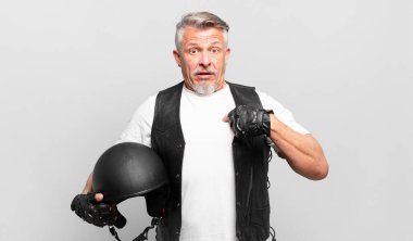 Son sınıf motosiklet sürücüsü mutlu, şaşkın ve gururlu hissediyor. Heyecanlı ve şaşkın bir bakışla kendini işaret ediyor.