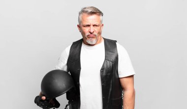 Son sınıf motosiklet sürücüsü üzgün, üzgün ya da kızgın hissediyor ve olumsuz bir tavır takınıyor, anlaşmazlıkla kaşlarını çatıyor.