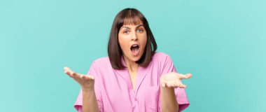 Güzel bir kadın son derece şok olmuş ve şaşırmış, endişeli ve panik içinde, stresli ve dehşete düşmüş bir bakışla