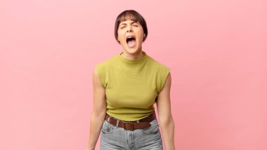 Güzel bir kadın agresif bir şekilde bağırıyor, sinirli, sinirli, öfkeli ya da sinirli görünüyor, hayır diye bağırıyor.