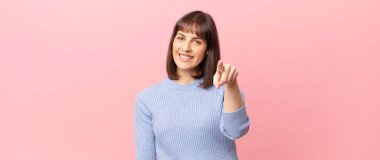 Tatmin olmuş, kendine güvenen, dostça gülümseyen ve seni seçen güzel bir kadın.