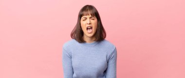 Güzel bir kadın agresif bir şekilde bağırıyor, sinirli, sinirli, öfkeli ya da sinirli görünüyor, hayır diye bağırıyor.