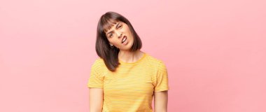 pretty woman feeling puzzled and confused, with a dumb, stunned expression looking at something unexpected