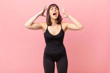 athlete woman screaming with hands up in the air, feeling furious, frustrated, stressed and upset