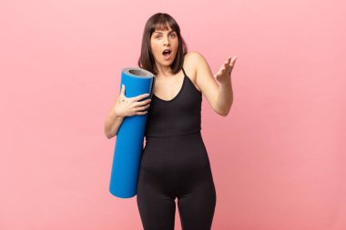 athlete woman feeling extremely shocked and surprised, anxious and panicking, with a stressed and horrified look