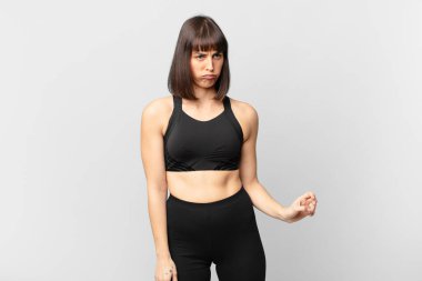 athlete woman feeling sad, upset or angry and looking to the side with a negative attitude, frowning in disagreement