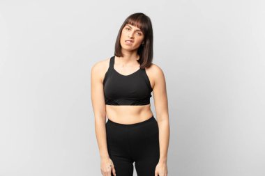 athlete woman feeling puzzled and confused, with a dumb, stunned expression looking at something unexpected