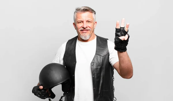 Senior Motorrad Fahrer Lächelt Und Schaut Freundlich Zeigt Nummer Drei — Stockfoto