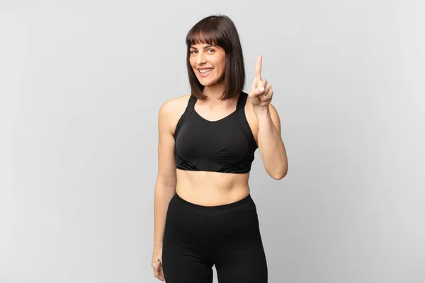 Athlete Woman Smiling Looking Friendly Showing Number One First Hand — Stockfoto