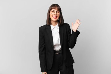 Genç iş kadını mutlu, şaşırmış ve neşeli hissediyor, olumlu bir tavırla gülümsüyor, bir çözüm ya da fikir buluyor.