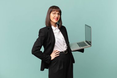 İş kadını mutlu bir şekilde gülümsüyor. Kendine güvenen, olumlu, gururlu ve arkadaş canlısı bir tavırla.