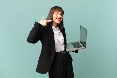 businesswoman smiling confidently pointing to own broad smile, positive, relaxed, satisfied attitude