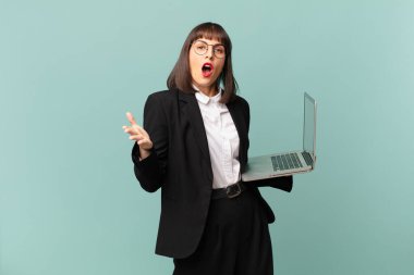 businesswoman feeling extremely shocked and surprised, anxious and panicking, with a stressed and horrified look