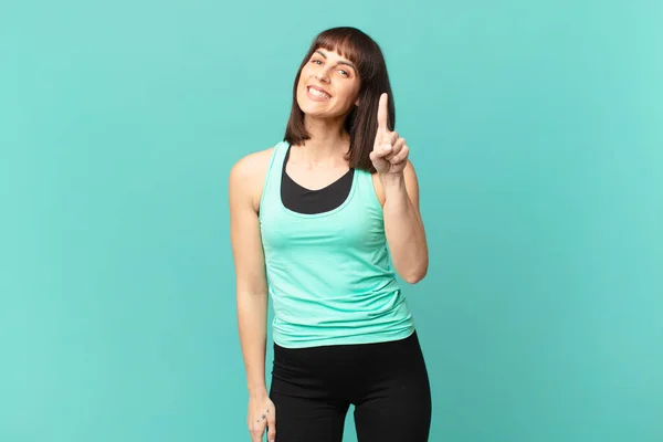 Atleta Mulher Sorrindo Olhando Amigável Mostrando Número Primeiro Com Mão — Fotografia de Stock