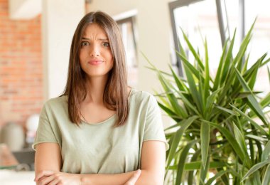 Güzel bir kadın kendini şaşkın ve şüpheci hissediyor, merak ediyor ya da karar vermeye çalışıyor.