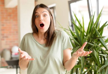 Güzel bir kadın son derece şok olmuş ve şaşırmış, endişeli ve panik içinde, stresli ve dehşete düşmüş bir bakışla