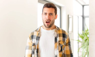 Yakışıklı adam şok olmuş, kızgın, sinirli ya da hayal kırıklığına uğramış, ağzı açık ve öfkeli görünüyor.