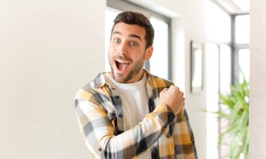 Yakışıklı adam mutlu, pozitif ve başarılı hissediyor, bir meydan okumayla karşılaştığında motive oluyor veya iyi sonuçları kutluyor.