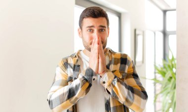 Yakışıklı adam mutlu ve heyecanlı, şaşırmış ve şaşırmış elleri ağızda, tatlı bir ifadeyle kıkırdıyor.