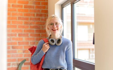 Güzel öğrenci mutlu ve hoş bir şekilde şaşırmış, büyülenmiş ve şok olmuş bir ifadeyle heyecanlanmış.