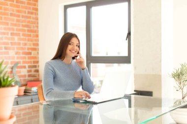 Güzel bir kadın mutlu bir şekilde gülümsüyor ve hayal kuruyor ya da şüphe ediyor.