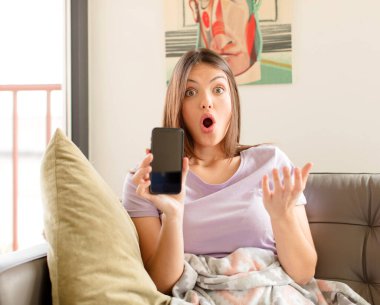 Güzel bir kadın son derece şok olmuş ve şaşırmış, endişeli ve panik içinde, stresli ve dehşete düşmüş bir bakışla