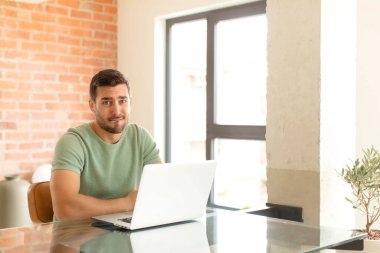 Yakışıklı adam şaşkın ve şaşkın görünüyor, gergin bir hareketle dudağını ısırıyor, sorunun cevabını bilmiyor.