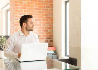 Profil görünümlü yakışıklı iş adamı ilerideki boşluğu kopyalamaya çalışıyor, düşünüyor, hayal ediyor ya da hayal kuruyor.