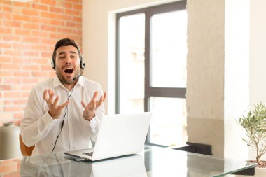 Yakışıklı pazarlamacı umutsuz ve sinirli görünüyor, stresli, mutsuz ve sinirli, bağırıyor ve çığlık atıyor.