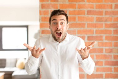 Yakışıklı iş adamı ağzı açık ve şaşırmış, şok olmuş ve hayrete düşmüş inanılmaz bir sürprizle