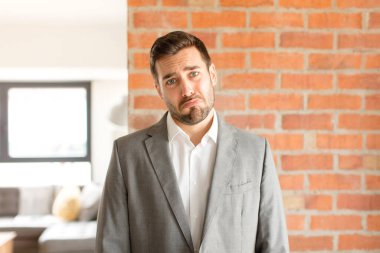 Yakışıklı iş adamı üzgün ve mızmız, mutsuz bir bakışla ağlıyor, olumsuz ve hayal kırıklığına uğramış bir tavırla ağlıyor.