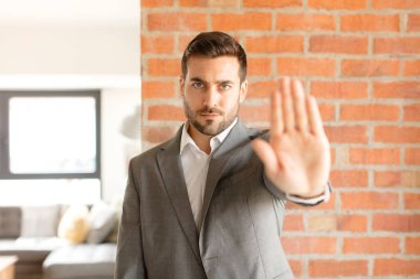 Yakışıklı iş adamı ciddi, sert, hoşnutsuz ve kızgın görünüyor.