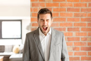 Yakışıklı iş adamı bağırıyor, çok kızgın, sinirli, öfkeli ya da sinirli görünüyor.