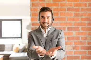 Yakışıklı tele pazarlamacı gülerek güler yüzlü, kendine güvenen, olumlu bakışlı, bir nesne ya da konsept sunan