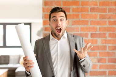 Yakışıklı mimar son derece şaşkın ve şaşırmış, endişeli ve panik içinde, stresli ve dehşete düşmüş bir bakışla